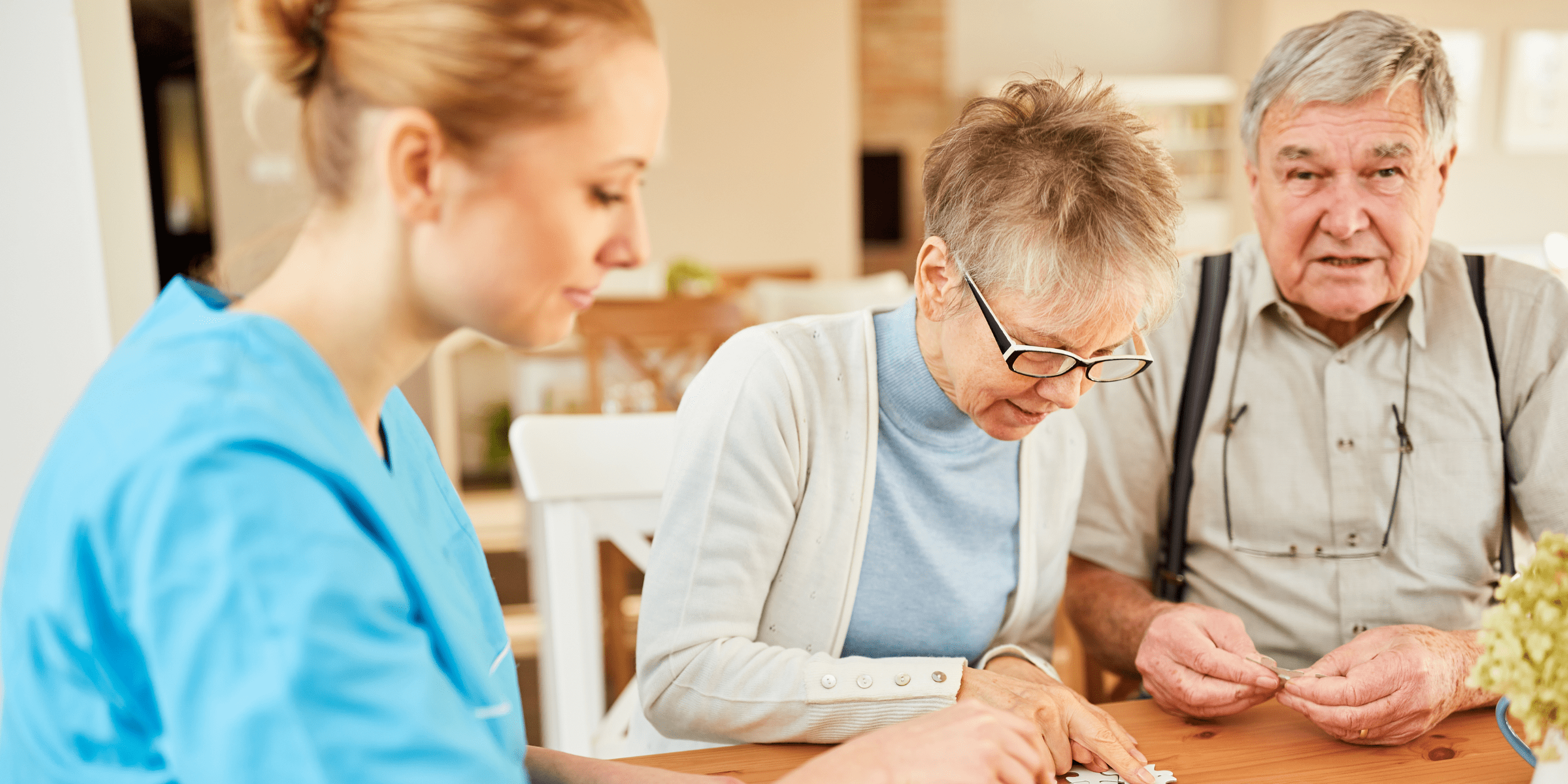 Couple de personnes âgées qui font un puzzle avec l'aide d'une femme jeune